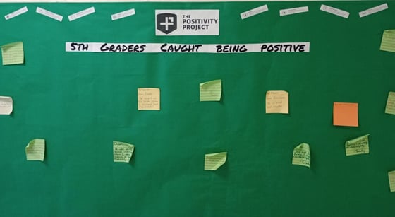 Bulletin board titled "5th Graders Caught Being Positive", with several colorful notes