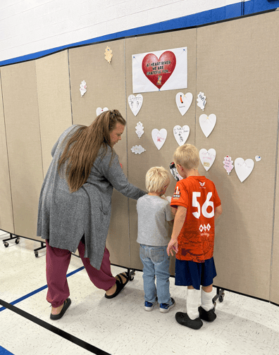 parents and kids in front of wall covered with paper hearts