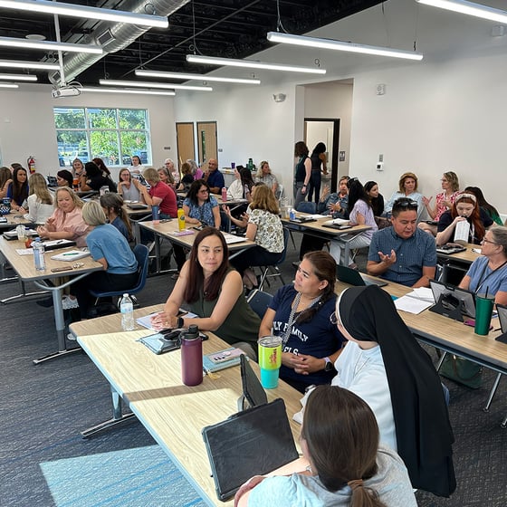 Teachers discussing in a classroom at a P2 training