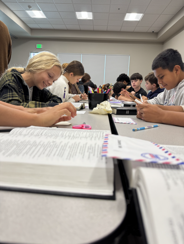 group-of-young-students-writing-at-their-desks
