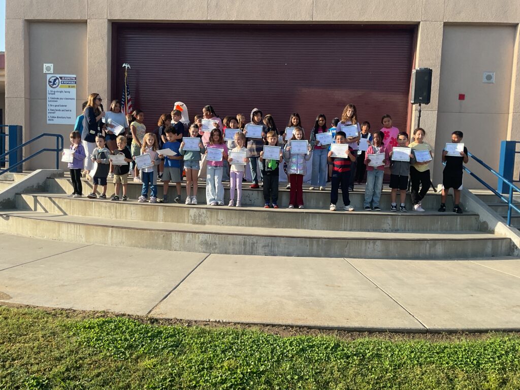 students-posing-with-signs-on-school-grounds