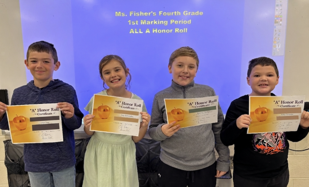 four-elementary-students-standing-in-row-holding-up-orange-and-white-papers