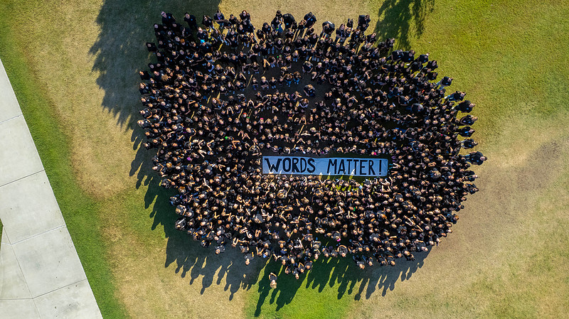 aerial-shot-of-students-all-wearing-black-shirts-with-blue-banner